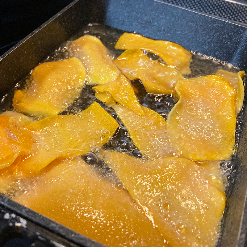 油でバターナッツかぼちゃを揚げている写真